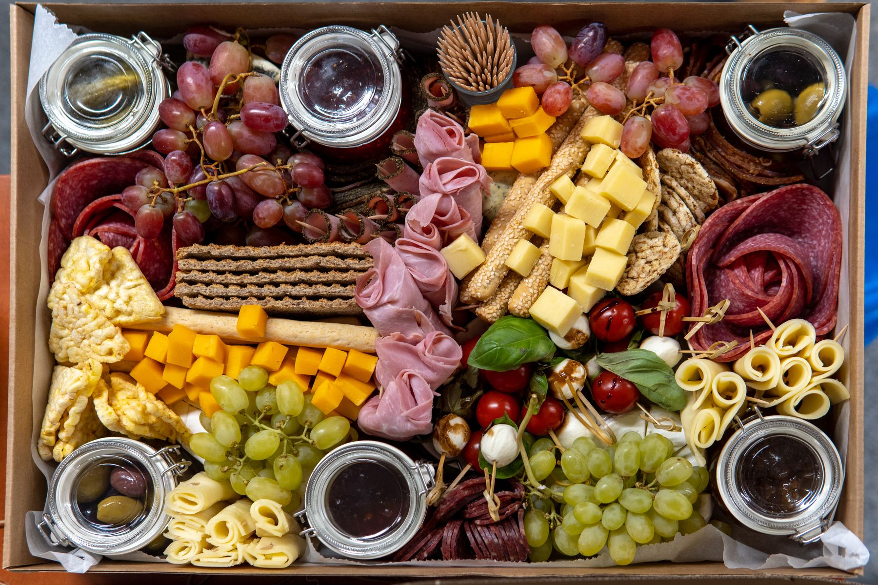 Nærbillede af charcuterie, ost og frugt på serveringsbræt