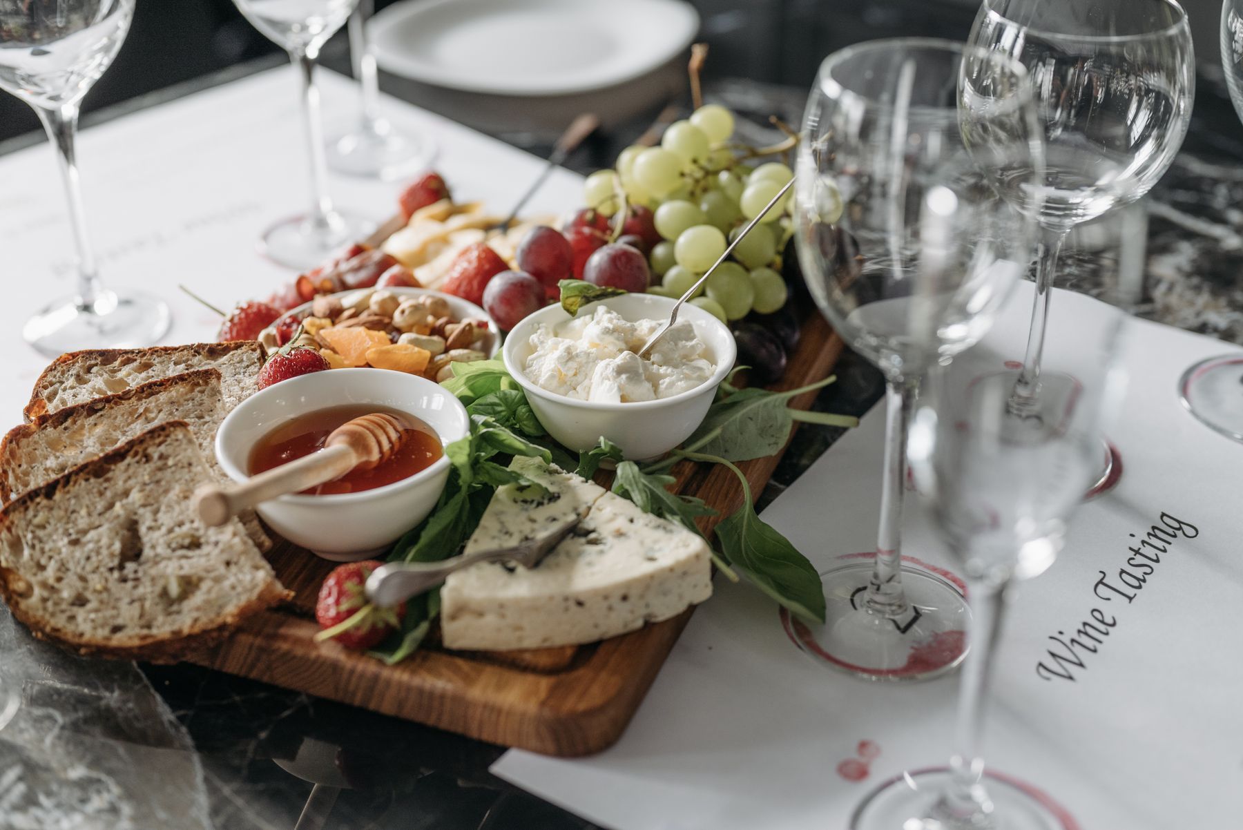 Elegant serveringsbræt med ost, frugt og brød